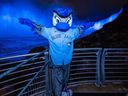 Toronto Blue Jays mascot Ace poses in front of Niagara Falls illuminated in blue in a handout photo.