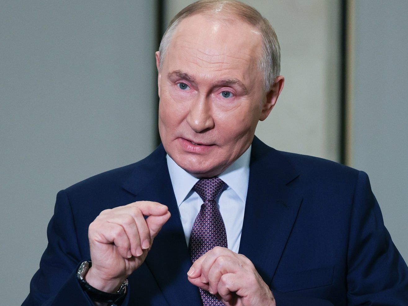 Russian President Vladimir Putin gestures while talking to reporters.