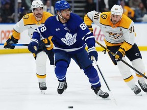 Maple Leafs winger William Nylander (88) is chased by Nashville Predators forwards Filip Forsberg (9) and Ryan O'Reilly (90) during the second period in Toronto on Tuesday, Oct. 14, 2025.