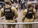 Military personnel, including the National Guard, patrol the subway system at Penn Station as officers check passengers' bags in New York City on Thursday, March 7, 2024.