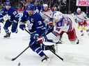 Maple Leafs captain Auston Matthews battles New York Rangers forward Will Kyle for the puck in Toronto on Thursday, Oct. 16, 2025.