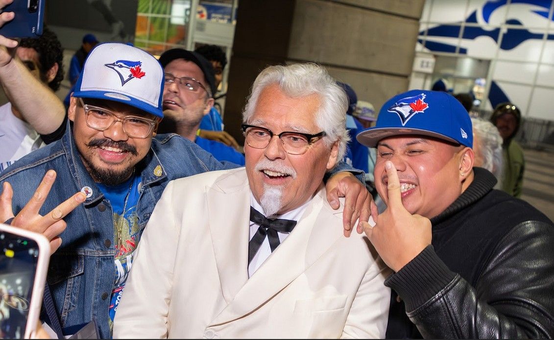 Actor Rob Willis, dressed as Colonel Saunders, pictured with Blue Jays fans. He played in Game 2 of the World Series as part of a KFC promotion. ((Narrative X PR/KFC))