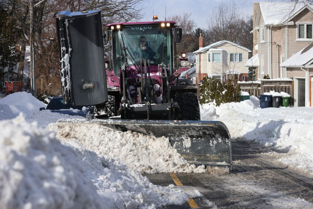 A snowplow tries to clear a path through buried cars and piles of snow on Cornell Avenue north of Kingston Road. and west of Worden Avenue on Monday, February 17, 2025.