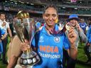India captain Harmanpreet Kaur poses with the trophy after defeating South Africa in the ICC Women's Cricket World Cup final.