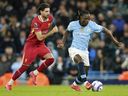 Manchester City's Jeremy Doku dribbles the ball followed by Liverpool's Dominik Szoboszlai during a game last season.