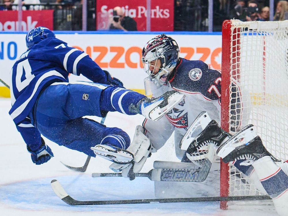 Toronto Maple Leafs winger Bobby McMann collides with Columbus Blue Jackets goaltender Jet Greaves during Tuesday's game.