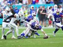 Josh Allen #17 of the Buffalo Bills loses the ball when he is hit by Jack Jones #23 of the Miami Dolphins during the fourth quarter of the game at Hard Rock Stadium on November 9, 2025 in Miami Gardens, Florida.