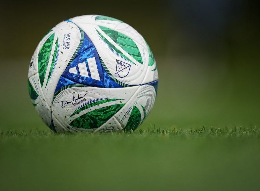 A soccer ball with the MLS logo and Commissioner Don Garber's signature sits on the pitch as the Vancouver Whitecaps practice, in Vancouver, on Wednesday, Oct. 22, 2025.