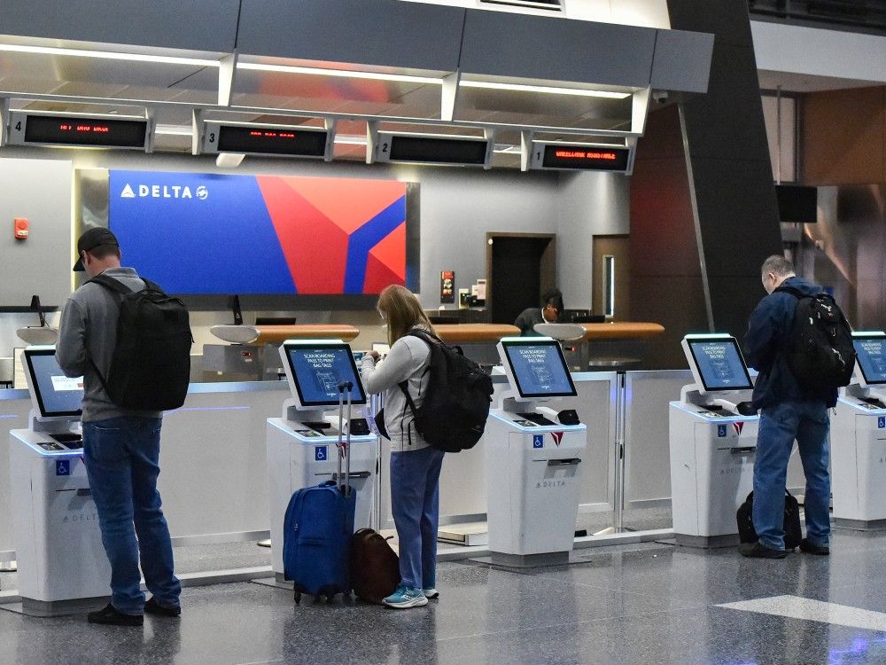Travelers check in at a Delta kiosk at Boston Logan International Airport on Monday, November 10, 2025.