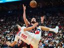 Raptors' Sandro Mamukelashvili, 54, and Washington Wizards' Keyshawn George compete for the ball at Scotiabank Arena on Friday, November 21, 2025.