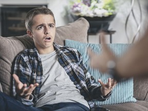 Teenage boy arguing and unhappy with parent
