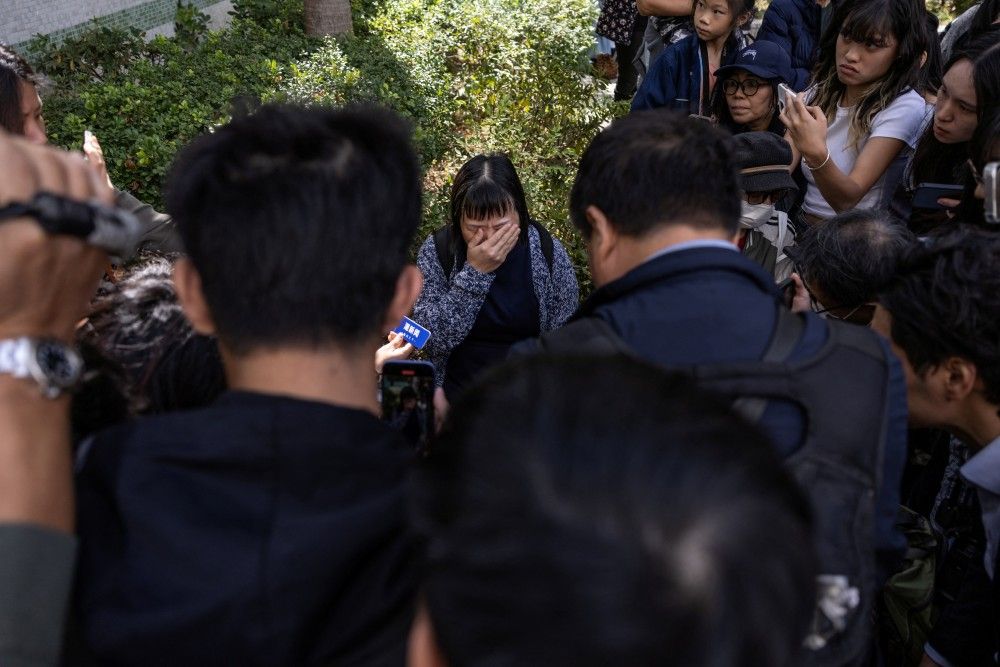 A resident reacts as she speaks to the media in the aftermath of a major fire that swept through several apartment blocks at the Wang Fuk Court residential estate in Hong Kong's Tai Po district, Friday, Nov. 28, 2025.