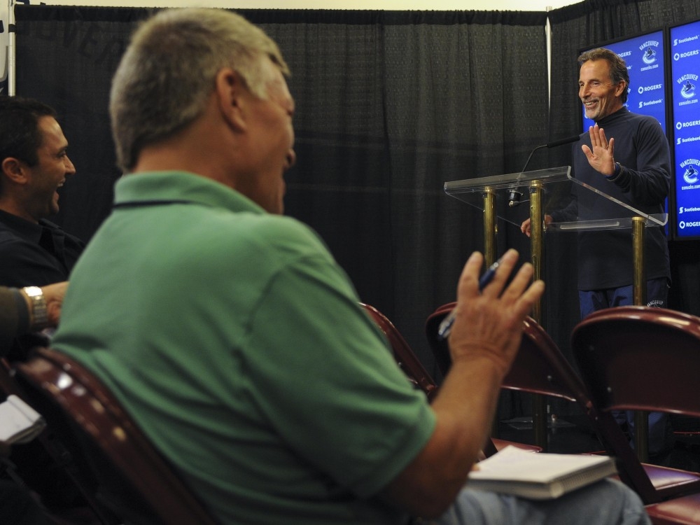  Canucks coach John Tortorella speaks to reporters, including New York Post columnist Larry Brooks (left in green), ahead of a game against the Rangers in Vancouver on Sept. 26, 2013.