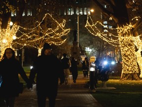Visitors to Queen's Park, Ontario's provincial legislature, walk among Christmas decorations on their front lawn in Toronto, Friday, Nov. 21, 2025.