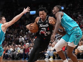 Toronto Raptors forward/guard Scottie Barnes drives past Charlotte Hornets forward Moussa Diabaté and guard Pat Connaughton on Monday night. Nathan Dennette/THE CANADIAN PRESS