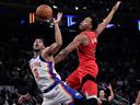 New York Knicks guard Josh Hart fights for control of the ball with Toronto Raptors forward Scottie Barnes during the first half of an NBA basketball game, Sunday, Nov. 30, 2025, in New York.