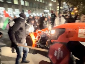 A city-contracted snowplow goes by a Palestinian protest.