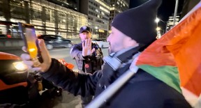A city-contracted snowplow goes by a Palestinian protest.