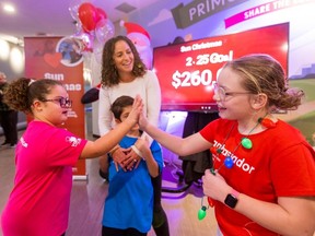 Christina Guzzo with her son Leo, while daughter Stella Leblanc-Beaudoin (left) chats with Madison (Madi) Ambos, Sun Christmas fund chair kid, during the kickoff to the Sun Christmas Fund at Variety Village in Toronto on Wednesday, Nov. 12, 2025.