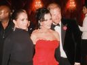 Kris Jenner (center in red) flanked by Meghan Markle and Prince Harry at Jenner's 70th birthday party.