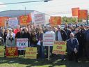 Several among the estimated 250 rally-goers attend a protest against the federal government's buyback program targeting prohibited firearms outside of Cape Breton Regional Police headquarters on Thursday, Oct. 2, 2025 in Sydney.