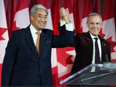 Prime Minister Mark Carney raises the hand of Michael Ma, Member of Parliament for Markham-Unionville, who crossed the floor from the Conservatives to the Liberals hours earlier, at the Liberal caucus holiday party in Ottawa on Thursday, Dec. 11, 2025.