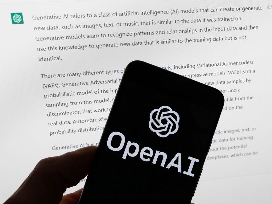 FILE - The OpenAI logo is displayed on a mobile phone in front of a computer screen with output from ChatGPT, March 21, 2023, in Boston.