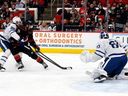 Carolina Hurricanes' William Carrier (28) is tied up by Toronto Maple Leafs' Oliver Ekman-Larsson and looses the puck on the way to Toronto Maple Leafs goaltender Joseph Woll (60) during the second period of an NHL hockey game in Raleigh, N.C., Thursday, Dec. 4, 2025. (AP Photo/Karl DeBlaker)