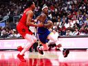 Jimmy Butler III #10 of the Golden State Warriors drives to the net against Scottie Barnes #4 of the Toronto Raptors during second half their NBA game at Scotiabank Arena on Sunday.