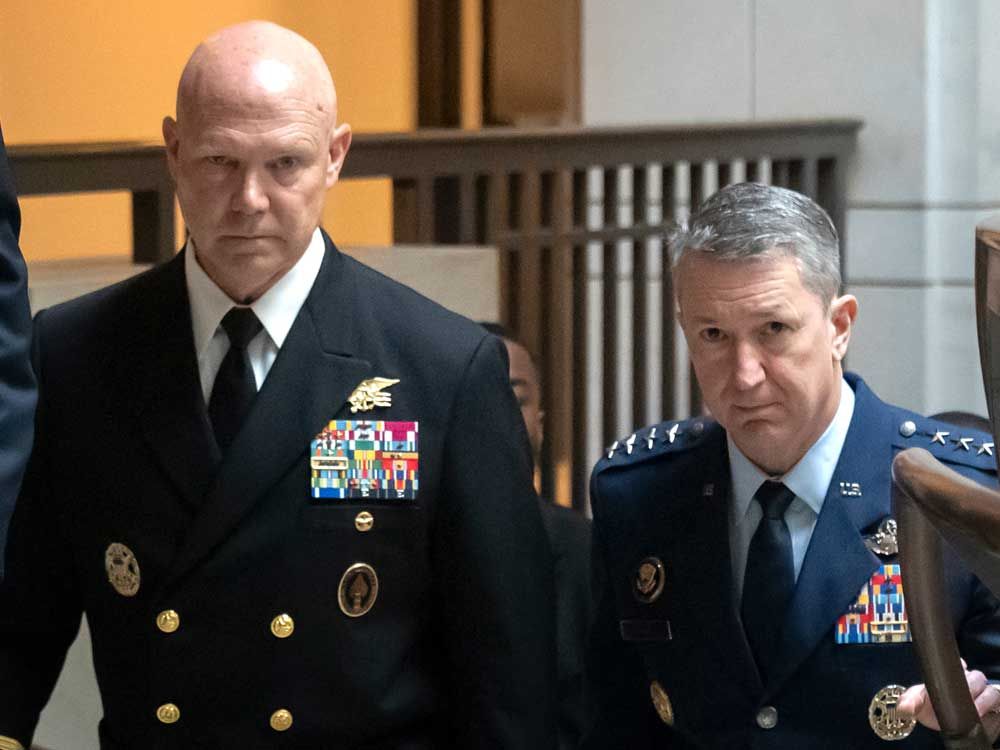 U.S. Navy Adm. Frank M. Bradley, accompanied by Gen. Dan Caine, chairman of the Joint Chiefs of Staff, right, walks to a meeting with senators on Capitol Hill, Thursday, Dec. 4, 2025, in Washington. 