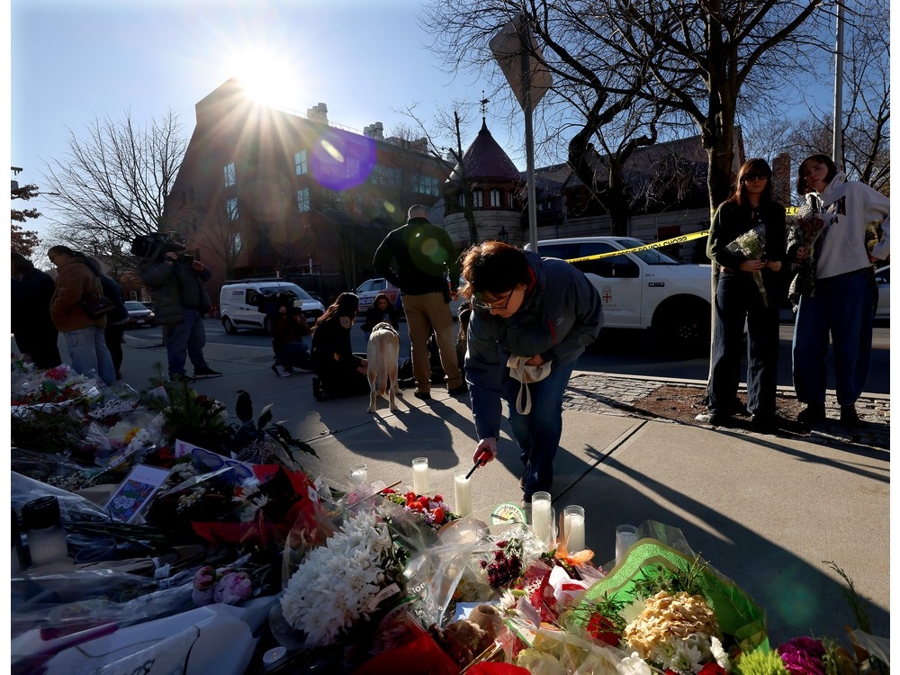  A woman lights a candle at a memorial set up in front of the Barus and Holley engineering building at Brown University in Providence, RI, Thursday, Dec. 18, 2025.