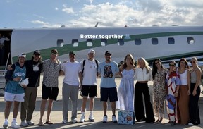 Toronto Blue Jays teammates and their partners stand in front of a plane.