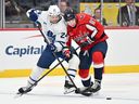 Scott Laughton of the Toronto Maple Leafs and Bogdan Trineyev of the Washington Capitals battle for control of the puck during a game earlier this season.