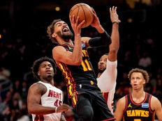 Atlanta Hawks guard Trae Young shoots past Miami Heat guard Davion Mitchell during a game in December.