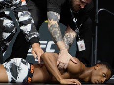 UFC fighter Cameron Smotherman lies on the stage after weighing in.