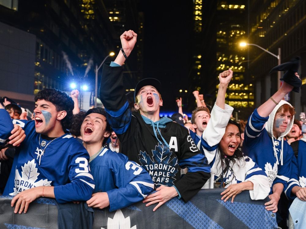 Toronto Maple Leafs fans react as they gather in Maple Leaf Square to watch a game.