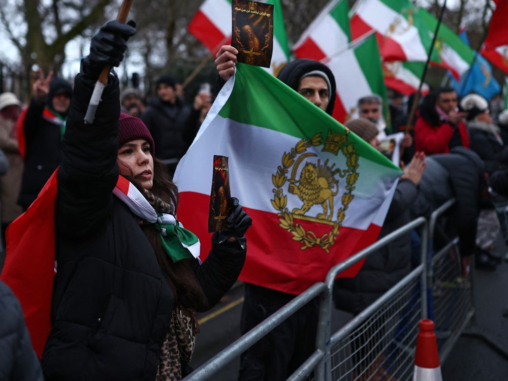 Anti-Iranian regime protesters wave the Iranian flag before the 1979 revolution with the Lion and Sun emblems during a gathering outside the Iranian Embassy, central London, on January 9, 2026.  
