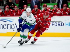 Vancouver Canucks defenseman Zeev Buium, left, moves the puck ahead of Detroit Red Wings right wing Patrick Kane during the first period of an NHL hockey game Thursday, Jan. 8, 2026, in Detroit.