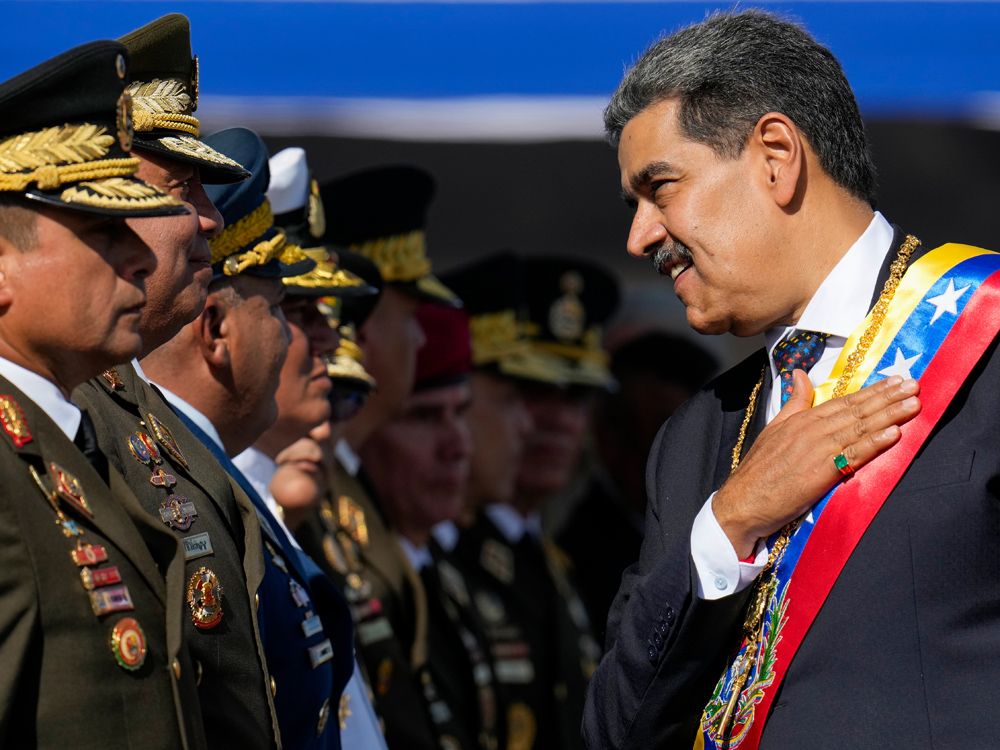 Venezuela's President Nicolas Maduro places his hand over his heart while talking to high-ranking officers during a military ceremony on his inauguration day for a third term, in Caracas, Venezuela, Jan. 10, 2025. 