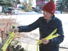 Alex Hansen removes police tape from the front of her yard in Edgemont on Tuesday.