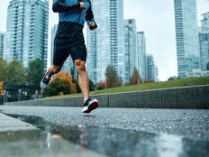 Unrecognizable athletic man running during rainy day.