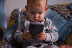 A little boy using a smart phone.