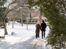 Back of woman and man strolling hand-in-hand along historic neighbourhood in Niagara-on-the-Lake.
