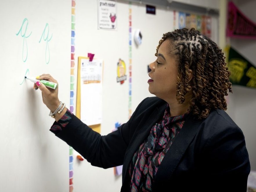  Teacher Sherisse Kennerson shows how to write the letter “Q” in cursive.  (Marvin Joseph/The Washington Post)