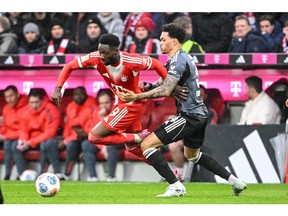 Bayern Munich's Alphonso Davies, left, and Frankfurt's Nnamdi Collins in action during the Bundesliga soccer match between Bayern Munich and Eintracht Frankfurt in Munich, Germany, on Feb. 21, 2026.