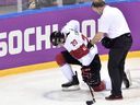 Canada forward John Tavares is helped off the ice after sustaining an injury during second period quarter-final hockey action against Latvia at the 2014 Sochi Winter Olympics in Sochi, Russia on Wednesday, Feb. 19, 2014.