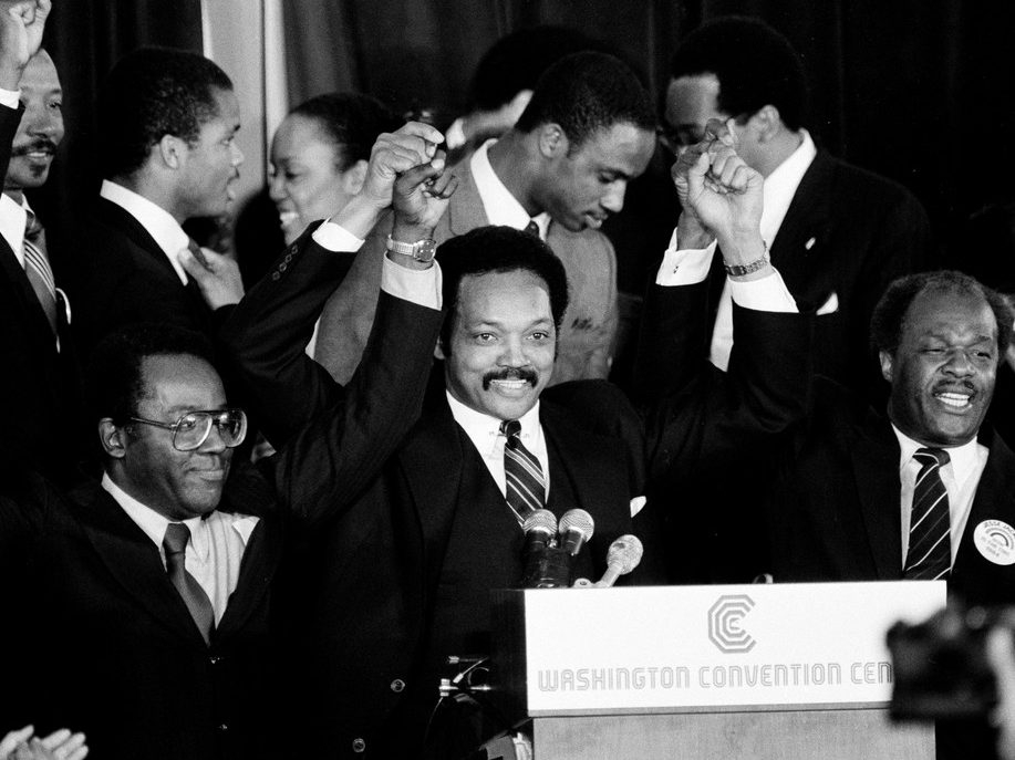  Jesse Jackson holds his hands up after announcing he will seek the Democratic nomination for president, with his campaign chairman Mayor Richard Hatcher, left, of Gary Ind., and Mayor Marion Barry of Washington, D.C., in Washington, Nov. 3, 1983.