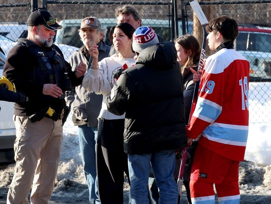  Hockey parents and a player speak to a police officer outside of the Lynch Arena in Pawtucket, R.I., after a shooting at the ice rink, Monday, Feb. 16, 2026.