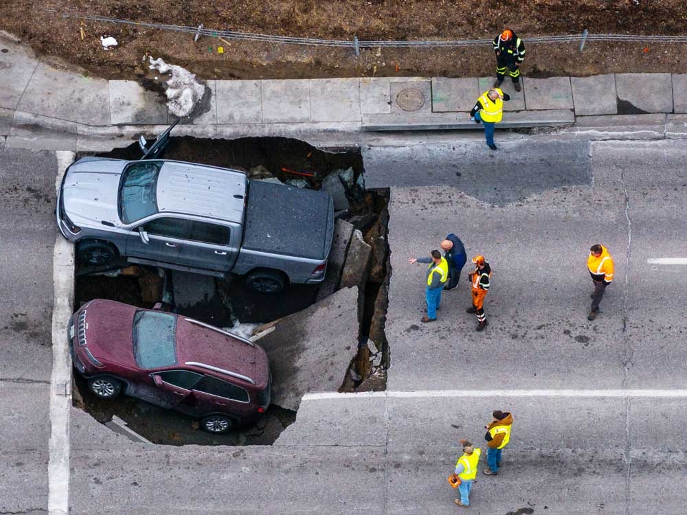  Authorities assess damage after two vehicles fell into a sinkhole on Pacific St. just east of 67th St. in Omaha, Neb., on Tuesday, Feb. 24, 2026.