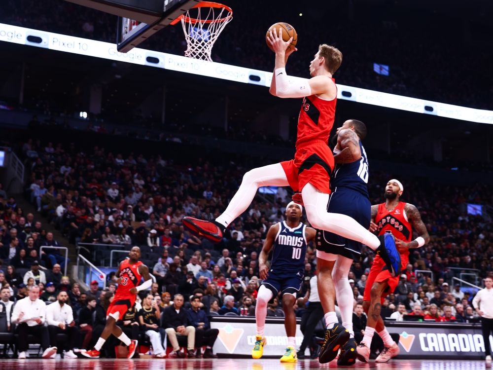 Gradey Dick of the Toronto Raptors drives to the net against Caleb Martin of the Dallas Mavericks during Sunday's game.